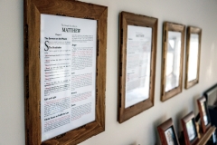 Bible pages framed above fireplace